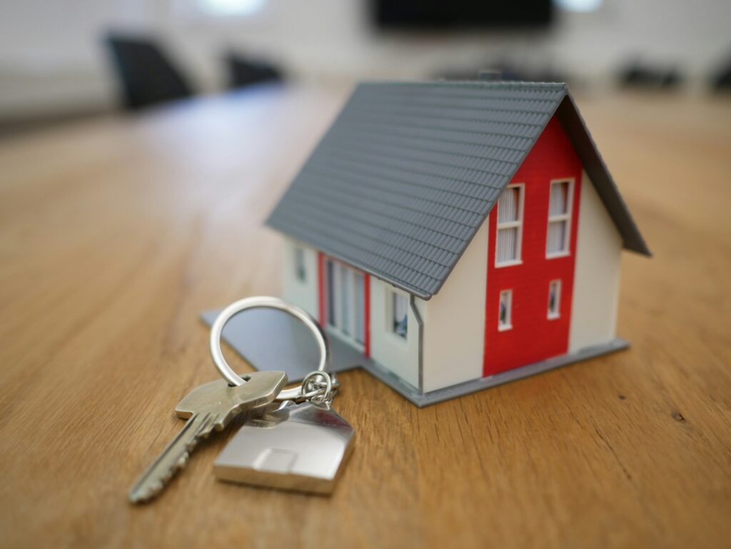 A tiny model house with keys representing a foreclosure