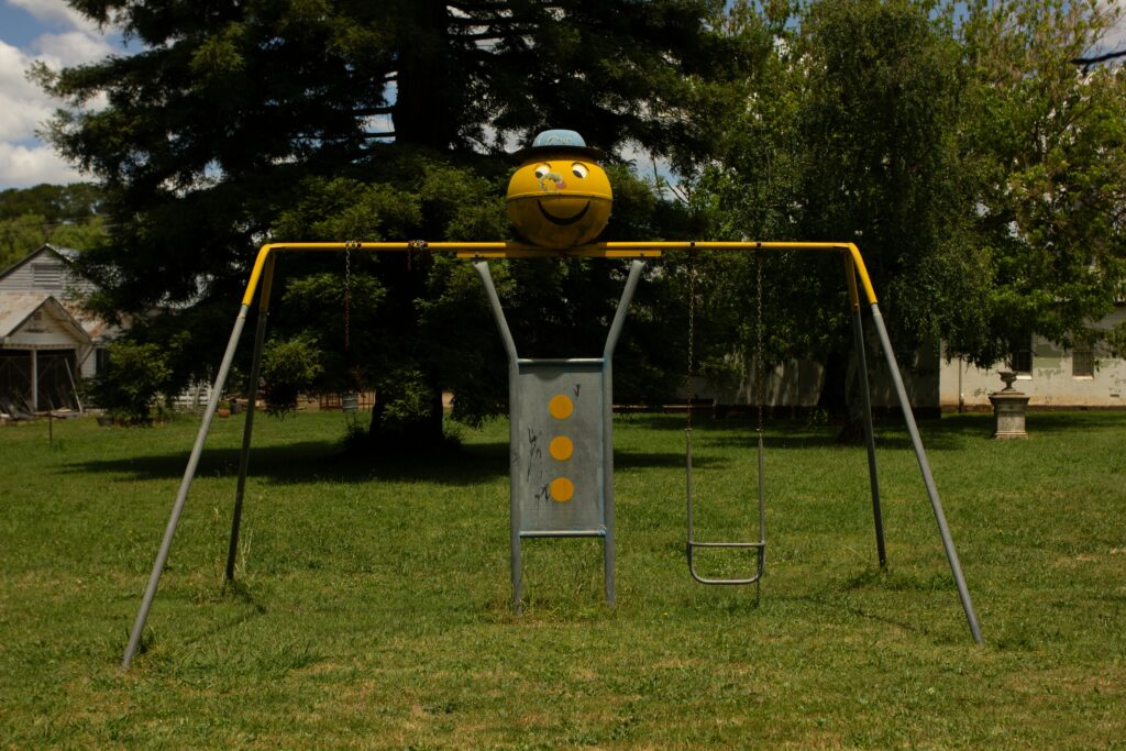 An old metal playset sitting alone in the middle of a yard