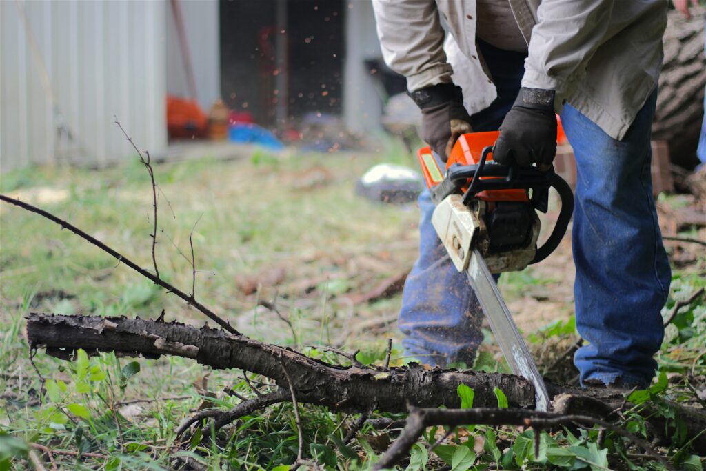 A person cutting up yard debris with a chainsaw